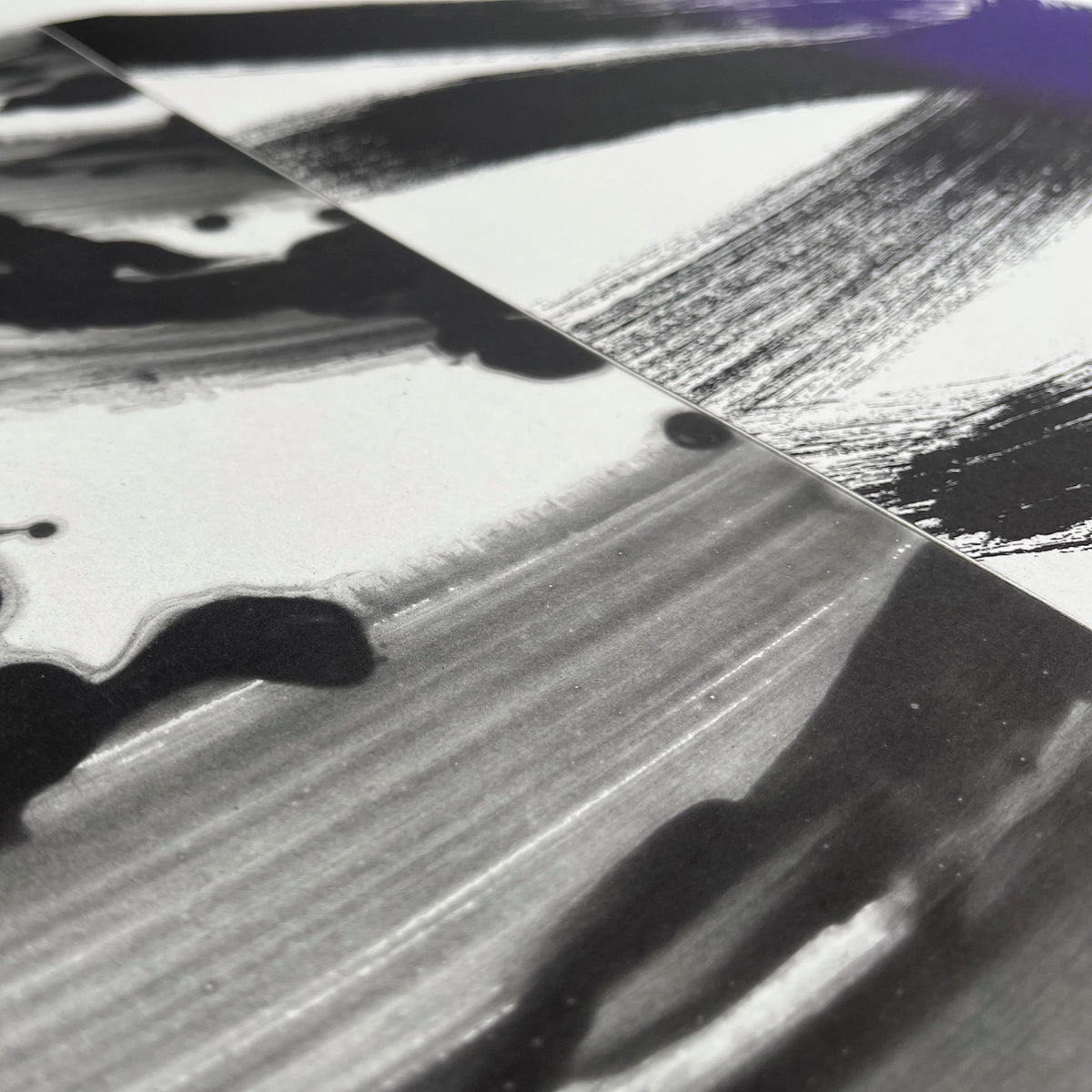 A close-up detail of an abstract etching featuring soft, fluid purple gradients on the left that contrast with bold, textured black and violet brushstrokes on the right.