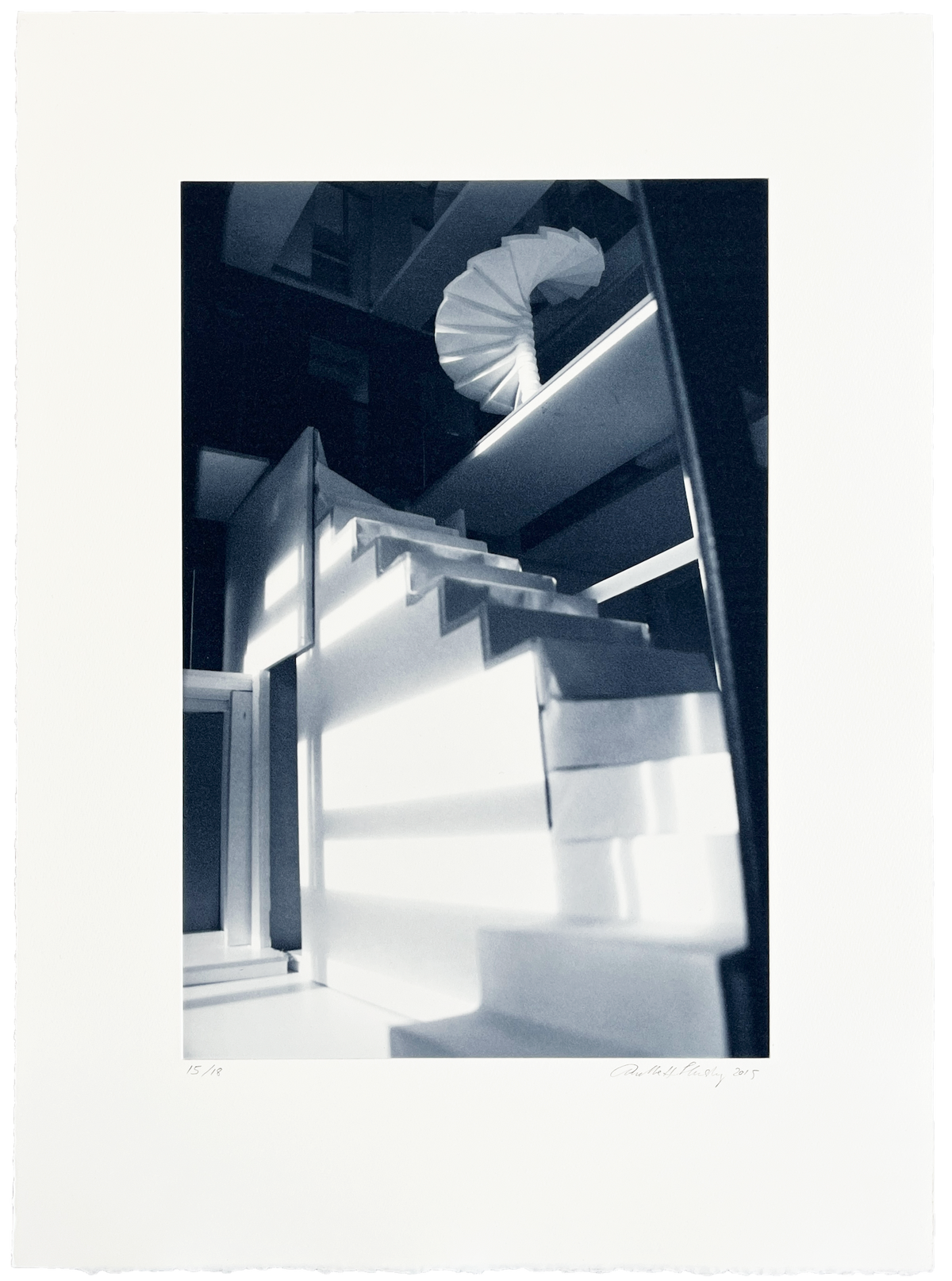 Anette Harboe Flensburg monochrome photogravure: an empty, quiet room with a winding staircase in rich shades of blue.