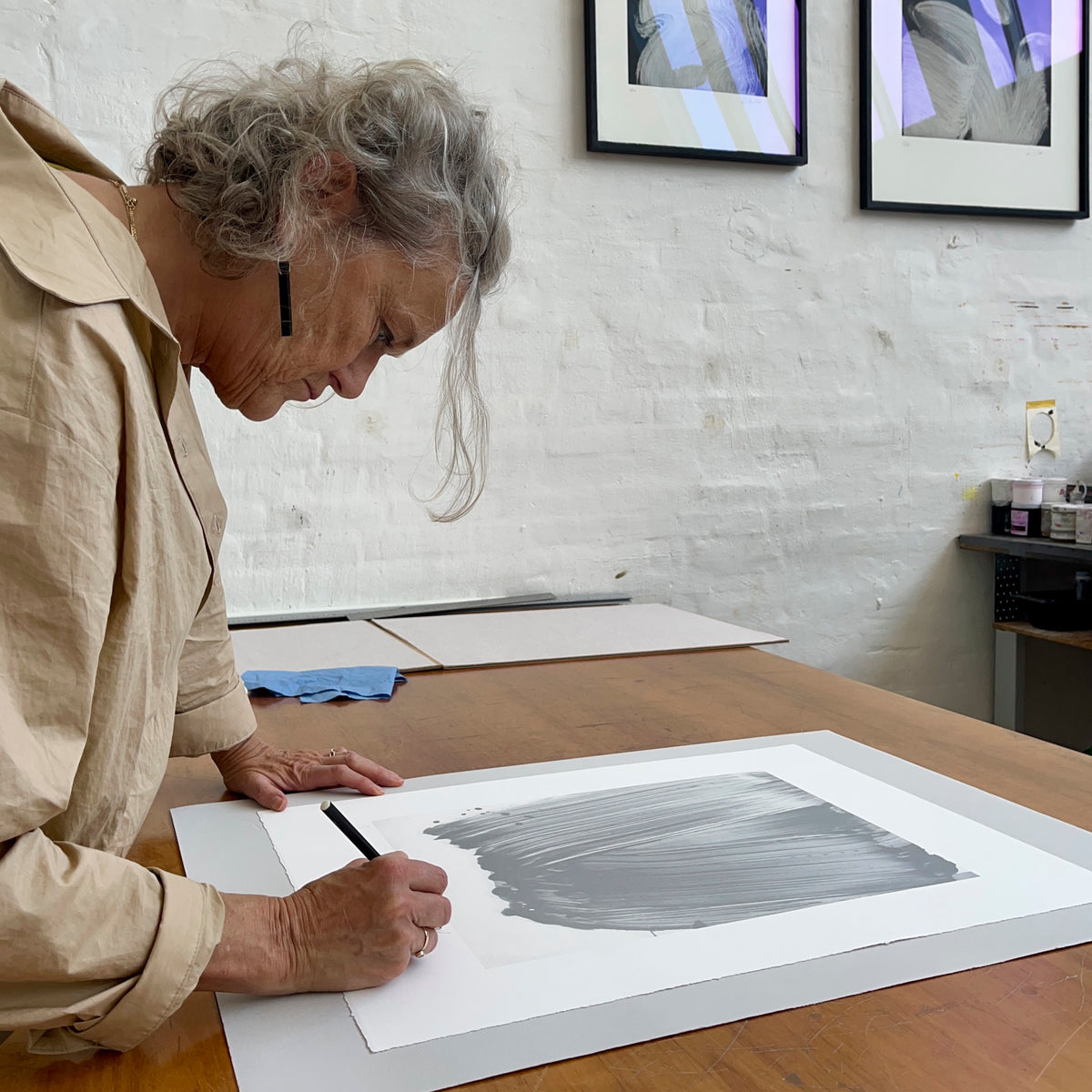 Artist Ruth Campau at Printer's Proof printmaking studio, signing a monoprint from her 'This Moment for You' series.