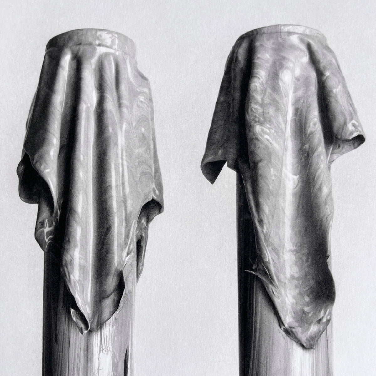 Detail from 'Ruin (III)' photogravure by Valérie Collart: gray-toned pillars draped in soft fabric with subtle metallic highlights. 